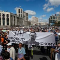 People attend a rally organized by Union of Journalists and approved by authorities in support of the investigative journalist Ivan Golunov in Moscow Sunday. The banner reads \"Freedom to Kirill Vyshinsky,\" referring to the director of the Ukrainian office of the Russian state news agency RIA Novosti, who was detained on treason charges in Kiev in 2018. | REUTERS
