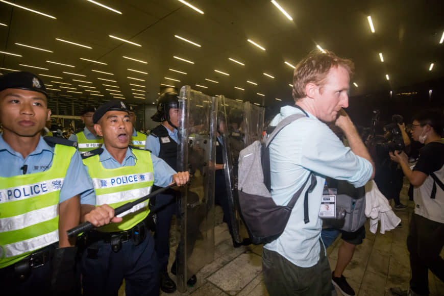 Police in riot gear direct journalists outside the Legislative Council in Hong Kong on Monday. | BLOOMBERG