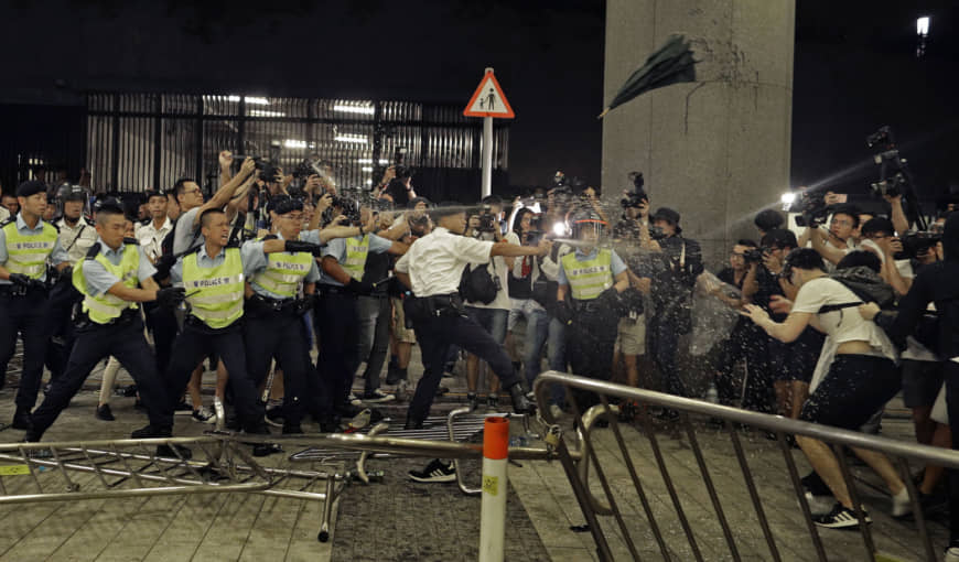 Police officers use pepper spray against protesters during a rally against proposed amendments to the extradition law at the Legislative Council in Hong Kong during the early hours of Monday | AP