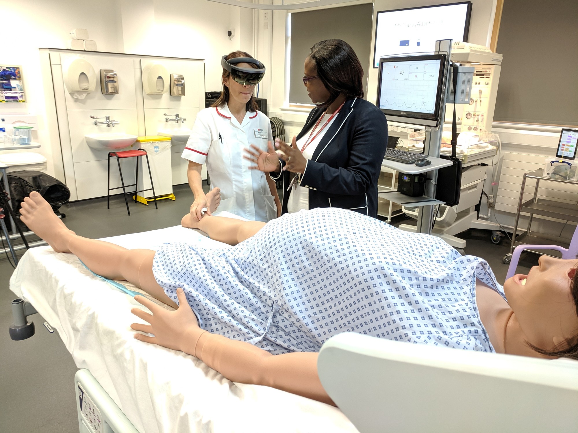 Midwifery educator at Middlesex University Sarah Chitongo instructs a trainee midwife wearing an augmented reality (AR) headset in London June 17. | REUTERS