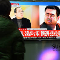 People watch a TV screen broadcasting a news report on the assassination of Kim Jong Nam, the older half brother of North Korean leader Kim Jong Un, at a railway station in Seoul in February 2017. | NEWS1 / VIA REUTERS