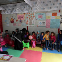 Displaced Syrian refugee children wait to receive psychological support at a mobile clinic in north Azaz, Syria, Sunday. | REUTERS