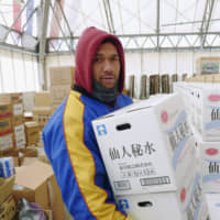 Former All Black Pita Alatini, who played for the Kamaishi Seawaves rugby club, carries relief supplies on March 19, 2011, in the town of Kamaishi, Iwate Prefecture, days after a mega-quake and tsunami hit the Tohoku region. | KYODO