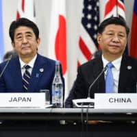 U.S. President Donald Trump, Prime Minister Shinzo Abe and Chinese President Xi Jinping attend a trilateral meeting at the Group of 20 summit Friday in Osaka. | AFP-JIJI