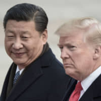 Chinese President Xi Jinping and U.S. President Donald Trump attend a welcome ceremony at the Great Hall of the People in Beijing in November 2017. | AFP-JIJI