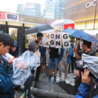 Protesters, both from Hong Kong and Japan, demonstrated against extradition legislation that would allow residents of Hong Kong to be sent to mainland China to face trial, in front of Osaka\'s Namba Station on Thursday evening. | ERIC JOHNSTON