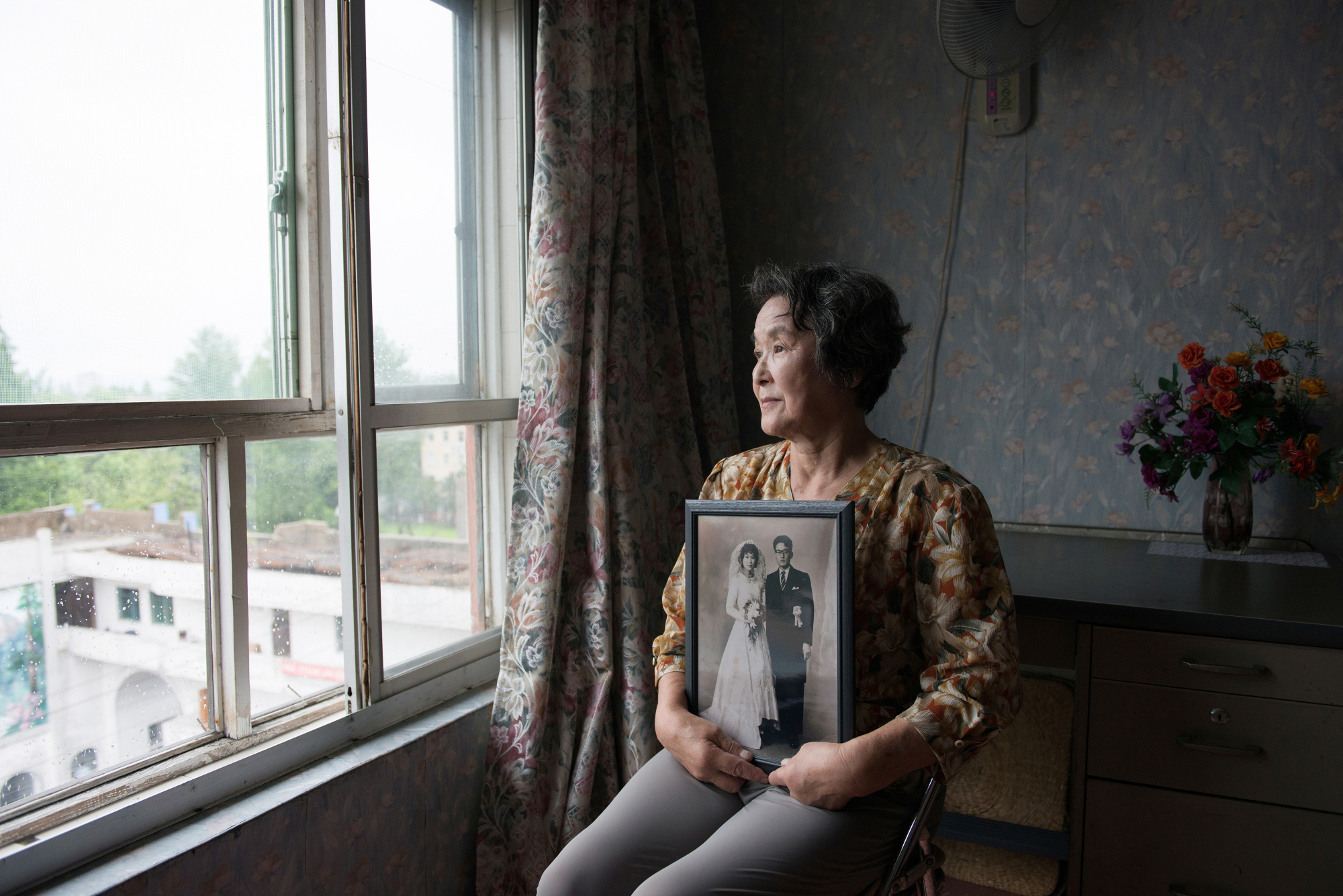 Mitsuko Minakawa, one of the Japanese wives who moved to North Korea, holds her wedding picture, taken in 1960 in Hakodate, Hokkaido, at her apartment in Wonsan in August 2016. | COURTESY NORIKO HAYASHI VIA KYODO