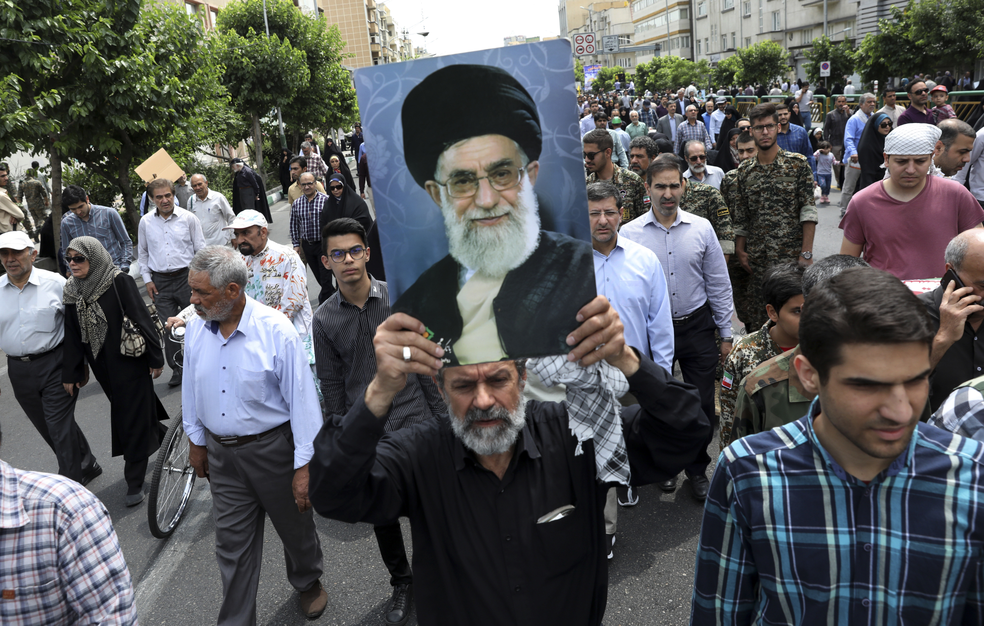 A demonstrator holds up a poster of Iranian Supreme Leader Ayatollah Ali Khamenei in Tehran on Friday during the annual Quds, or Jerusalem Day, rally. | AP