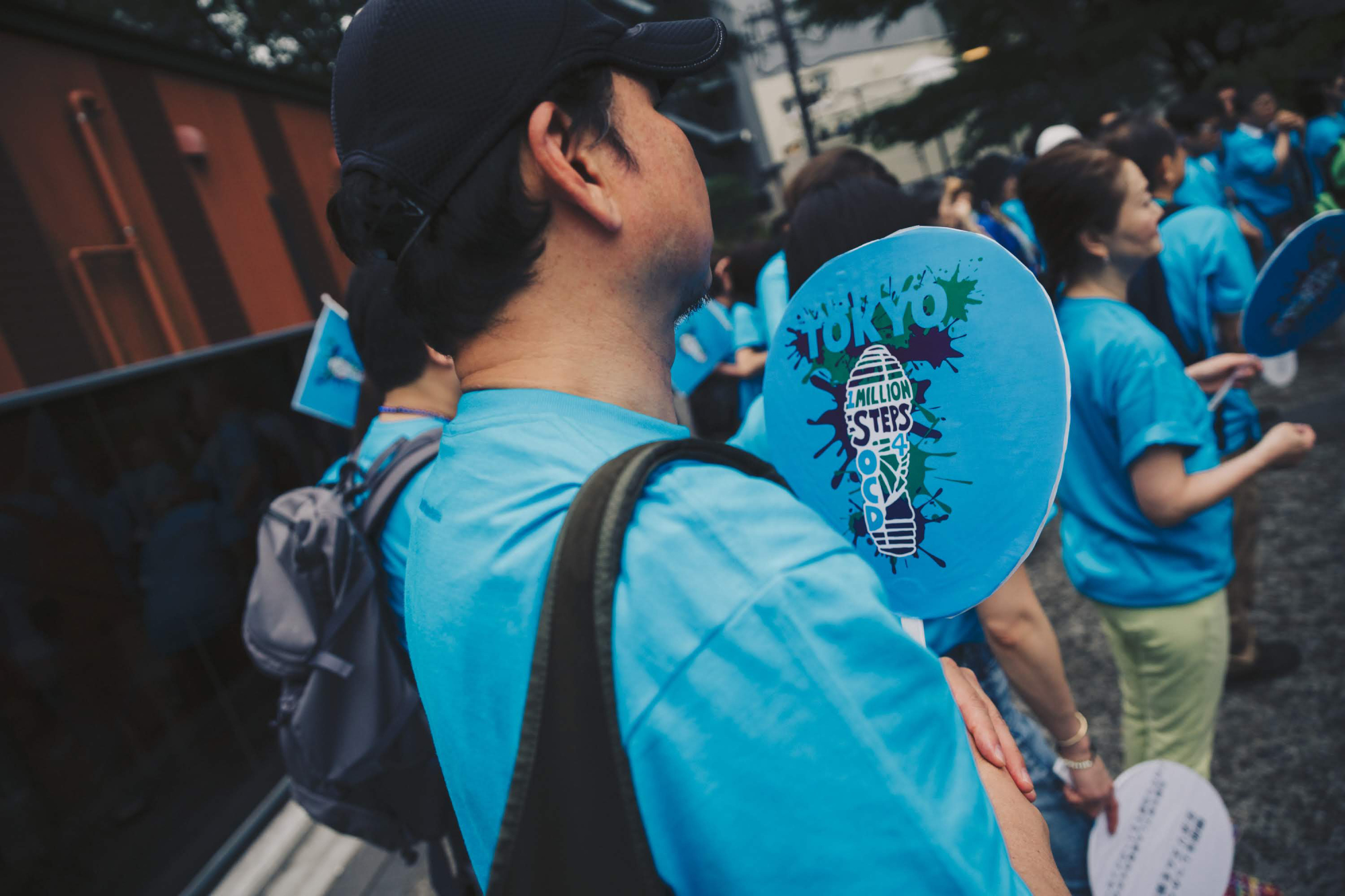 A participant of the OCD Walk held in Shibuya Ward, Tokyo, on June 2 holds a fan with a logo of the event. | DAISUKE ENOKI