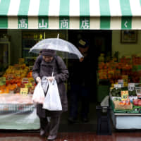 An elderly woman exits from a greengrocer\'s in Tokyo\'s Sugamo district, an area popular with retired people. | REUTERS