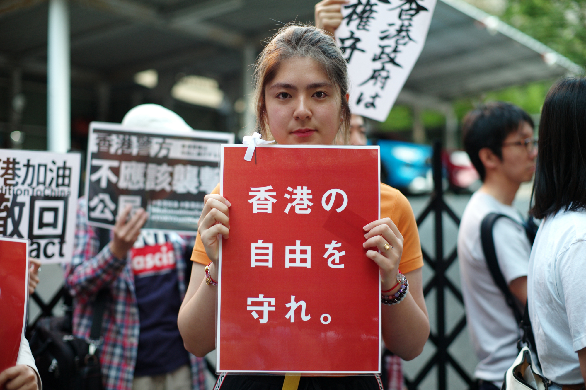Mandy Tang, 19, an exchange student from Hong Kong, holds a poster reading 'Protect the Freedom of Hong Kong' on Thursday in Tokyo's Chiyoda Ward during a rally against the semiautonomous region's controversial extradition bill. | RYUSEI TAKAHASHI