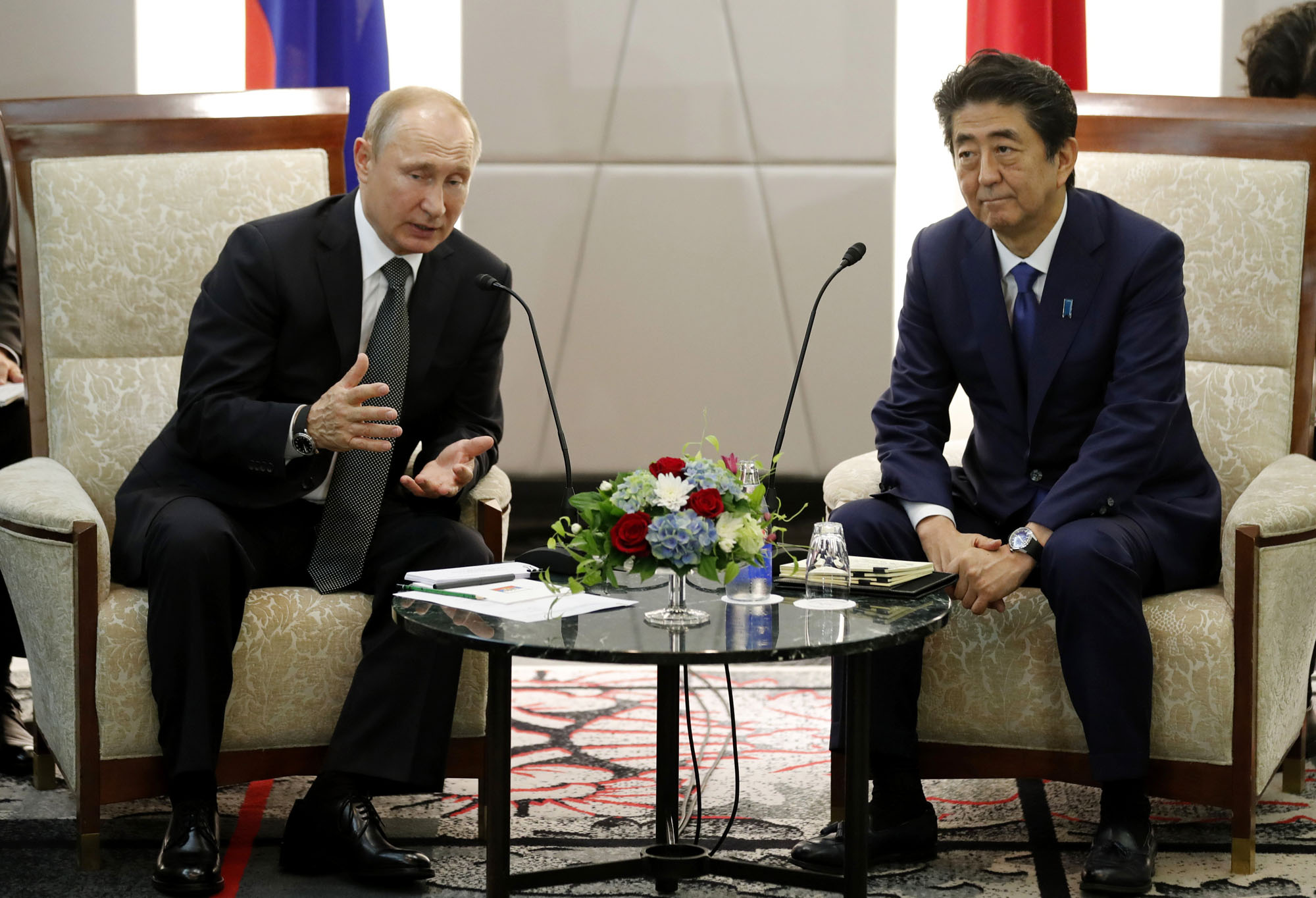 Russian President Vladimir Putin speaks with Prime Minister Shinzo Abe during a bilateral meeting on the sidelines of the G20 summit in Osaka on Saturday. | BLOOMBERG
