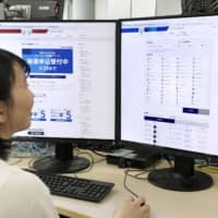A woman checks the Tokyo Olympics ticket application website, in Tokyo on May 9. A law banning ticket scalping has come into force ahead of the 2020 Games. | KYODO