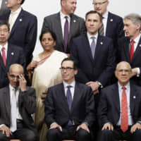 Group of 20 finance ministers and central bank governors get ready for a family photo in Fukuoka on June 9. | BLOOMBERG