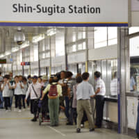 Passengers disembark and board a train at Yokohama Seaside Line Co.\'s Shin-Sugita Station in Yokohama on Tuesday as automated trains resumed services, with drivers in control, three days after an accident involving one of the trains. | KYODO
