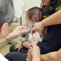 A baby is given a measles and rubella vaccine near Tokyo in 2015. | KYODO