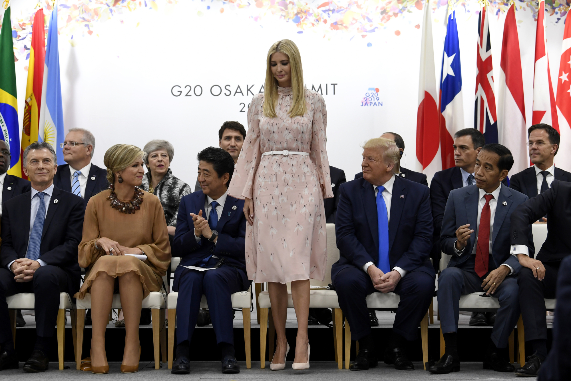 Ivanka Trump stands up to speak at a G20 summit event on women's empowerment in Osaka on Saturday. | AP