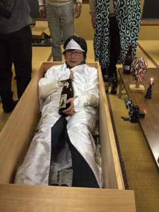 A villager dressed in death robes drinks from a bottle of sake during the Jalanpon festival in the village of Kuna in Chichibu, Saitama Prefecture. | COURTESY OF SHIN SASAKUBO