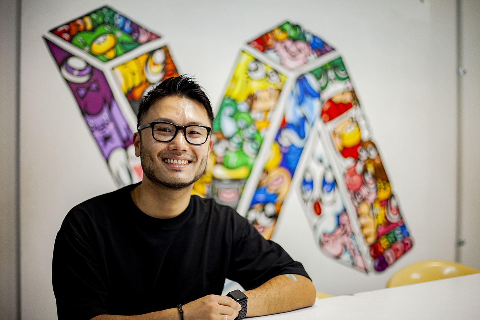 Walls of color: Jun Arita with one of his murals commissioned for the Skinnies studio space in Auckland | TODD PACEY