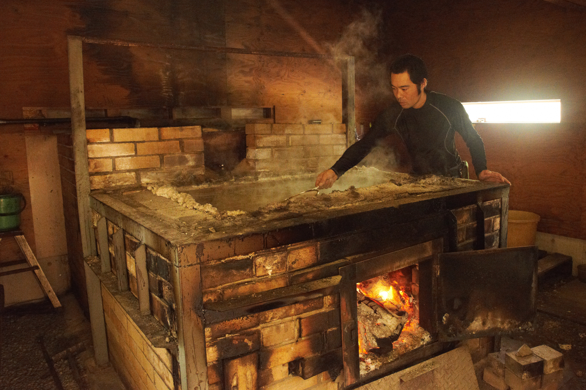 Turning up the heat: Concentrated sea water is evaporated above a wood fire to create salt solids. | KENTA IZUMI