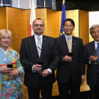 Polish Ambassador Jacek Izydorczyk (second from left) and his wife, Magdalena (left), welcome Parliamentary Vice-Minister for Foreign Affairs Kenji Yamada (second from right) and Chairman of  the Japan-Poland Parliamentary Friendship Association Hirofumi Nakasone during a reception to celebrate the 100th anniversary of diplomatic relations between Poland and Japan and Poland\'s national day at Hotel New Otani on May 23. | YOSHIAKI MIURA