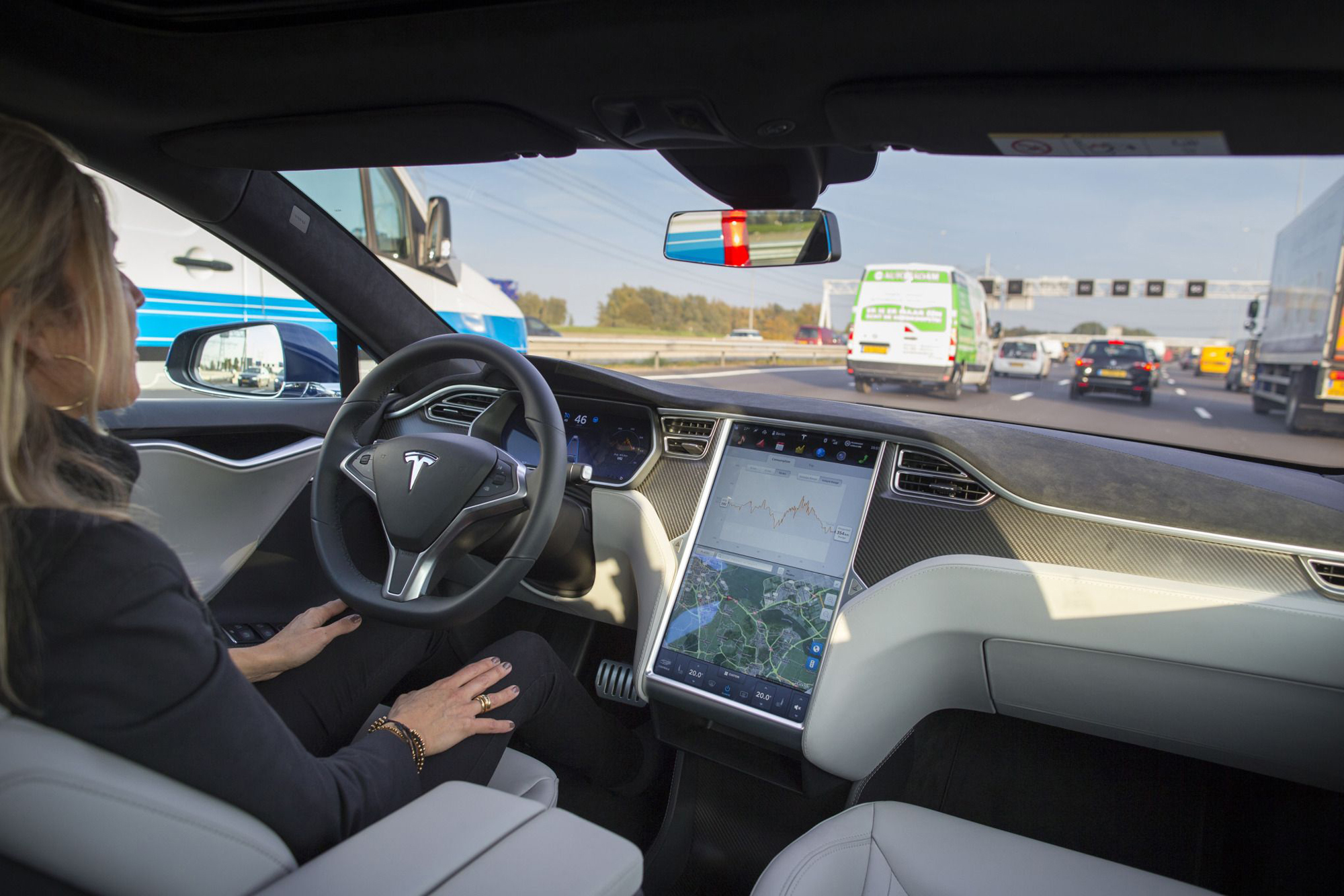 A Tesla employee drives a Model S equipped with autopilot technology on a highway in Amsterdam in 2015. | BLOOMBERG