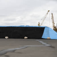A stockpile of coal stands at a port in Aomori on April 26. Japan is currently the only Group of Seven country that is adding to its domestic coal power-generation capacity. | BLOOMBERG