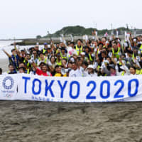 Participants in a trash-collecting event pose at Tsurigasaki Beach in Chiba Prefecture on Wednesday. | KYODO
