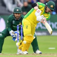 Australia\'s David Warner is watched by Pakistan captain Sarfaraz Ahmed as he plays a shot in a Cricket World Cup group stage match on Wednesday in Taunton, England. | AFP-JIJI