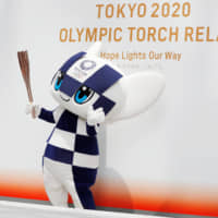Tokyo 2020 mascot Miraitowa holds the torch for the 2020 Summer Olympics during an event on June 1 in Tokyo. The first round of applications for the torch relay began Monday. | REUTERS