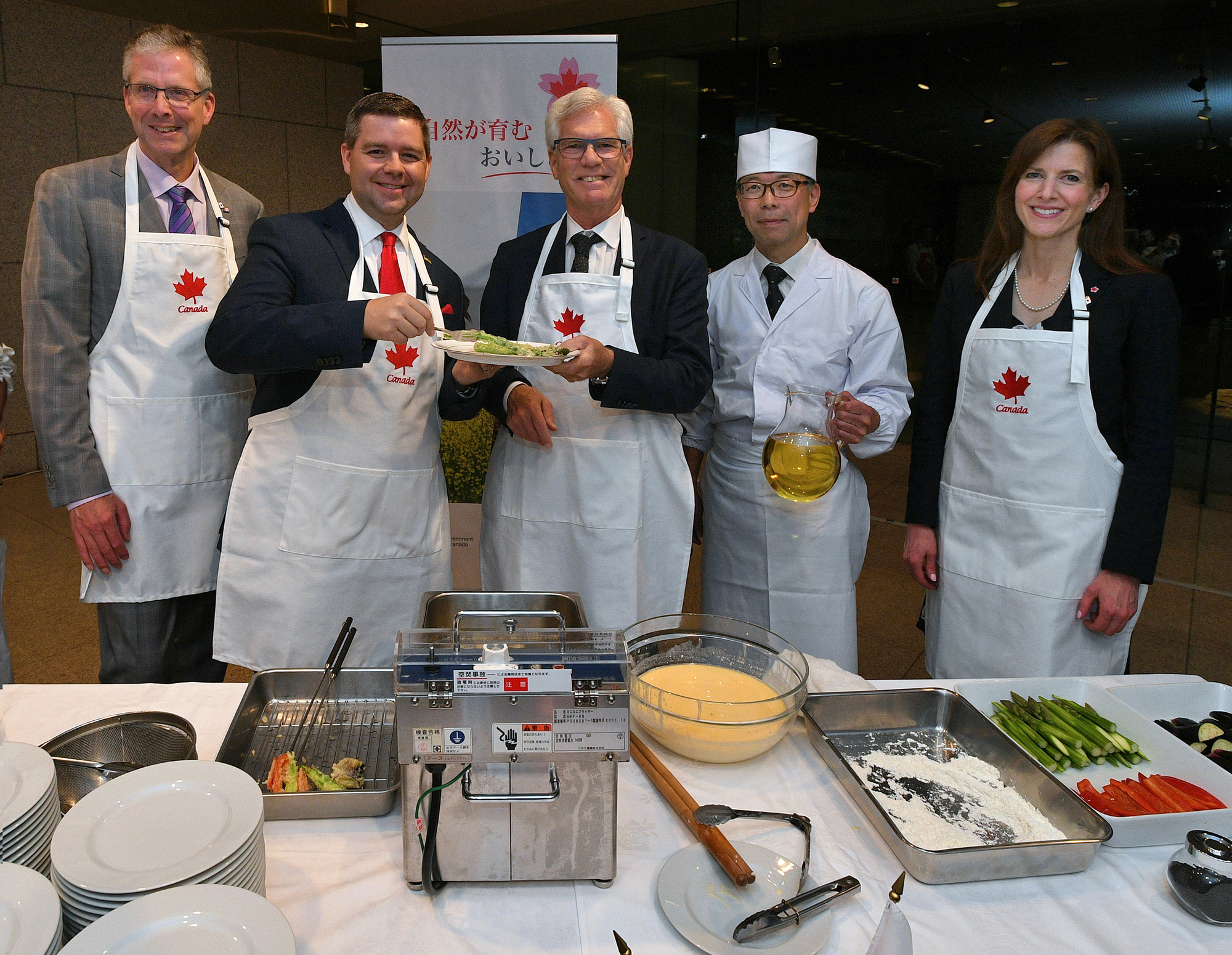 Canadian Minister of International Trade Diversification Jim Carr (center) poses with (from left) Canadian Ambassador Ian Burney,  Saskatchewan Minister of Trade and Export Development and Minister of Immigration and Career Training Jeremy Harrison, tempura master Toshio Sawabe and Alberta Minister of Economic Development, Trade and Tourism Tanya Fir during a tempura demonstration using canola oil from Canadian seeds at an event to promote Canadian food at the Canadian Embassy on June 6. |   YOSHIAKI MIURA
