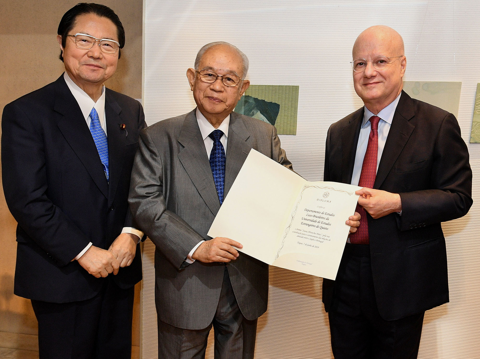 On June 7, during a reception at Hillside Banquet, Tokyo to celebrate Portugal's national day, the Portuguese Embasy awarded the Kyoto University of Foreign Studies' (KUFS) Department of Brazilian and Portuguese Studies with the third Joana Abranches Pinto Award. Portuguese Ambassador Francisco Xavier Esteves (right) poses with Yoshikazu Morita, chancellor and chair of the KUFS board of governors (center) and Seishiro Eto, chairman of the Japan-Portugal Parliamentary Friendship League. The award is funded by donations from former Vice-Consul Joana Abranches and is conferred to persons or groups who contribute to strengthening relations between the two countries, particularly in terms of culture. | YOSHIAKI MIURA