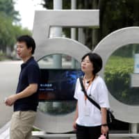 Employees wait for a shuttle bus at a 5G testing park at Huawei\'s headquarters in Shenzhen, Guangdong province, China, in May. | REUTERS