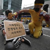 A South Korean protester wearing a mask of Prime Minister Shinzo Abe performs during a rally denouncing Japan for its enforcement of tighter export controls near the Japanese Embassy in Seoul on Saturday. | AFP-JIJI