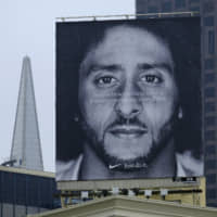 A large billboard stands on top of a Nike store showing former San Francisco 49ers quarterback Colin Kaepernick, at Union Square in San Francisco last fall. Nike is pulling a flag-themed tennis shoe after Kaepernick complained to the shoemaker, according to the Wall Street Journal. | AP