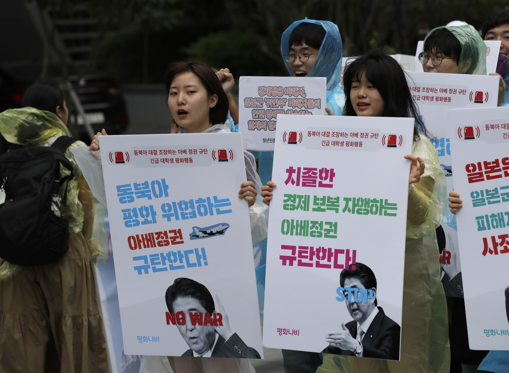 South Korean students shout slogans as they march to denounce the Japanese government's decision to impose some restrictions on exports, near the Japanese Embassy in Seoul on Wednesday. | AP