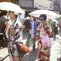 Tourists walk along a Kyoto street. | KYODO