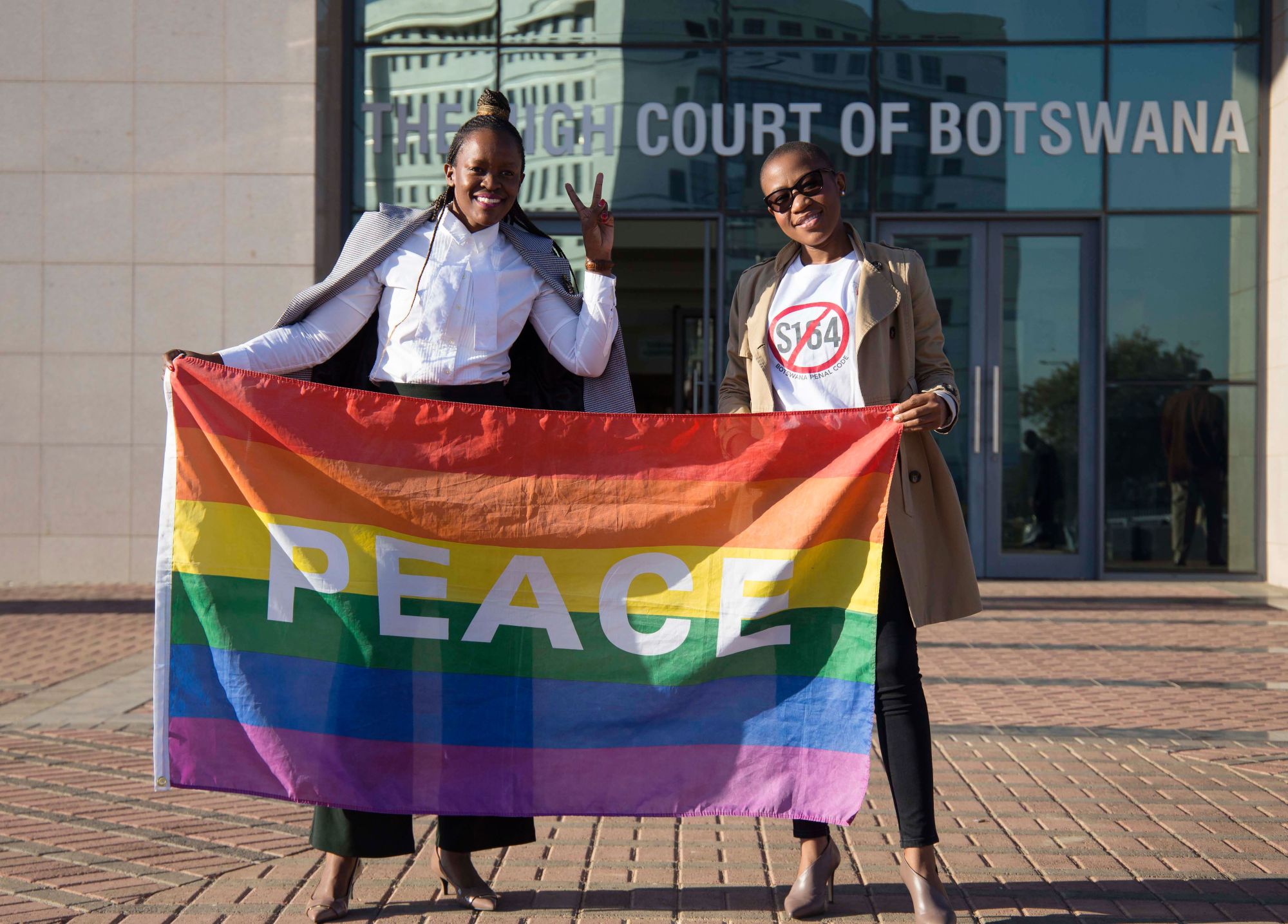 Activists hold the rainbow flag as they celebrate outside the Botswana High Court in Gaborone on June 11. The country's attorney general said Friday that the government will appeal last month's landmark high court ruling that decriminalized homosexuality. | AFP-JIJI