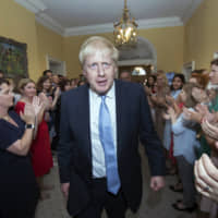 Staffers at No. 10 Downing St. welcome new Prime Minister Boris Johnson on Wednesday. | AP