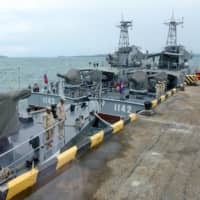 Cambodian naval personnel are seen on boats berthed at a jetty at the Ream naval base in Preah Sihanouk province on Friday during a government-organized media tour. | AFP-JIJI