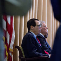 Steven Mnuchin, U.S. Treasury secretary (left), and Charles Rettig, commissioner of the Internal Revenue Service (IRS), listen during an IRS Criminal Investigation 100th year anniversary event at the IRS headquarters in Washington on Monday. | BLOOMBERG