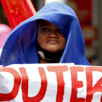 A protester displays a sign during a rally near the presidential palace in Manila on Friday to call for the impeachment of President Rodrigo Duterte. | AP
