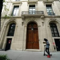 A man walks past the front door of the Upper East Side home of Jeffrey Epstein, after the Southern District of New York announced charges of sex trafficking of minors and conspiracy to commit sex trafficking of minors, in New York July 8. | REUTERS