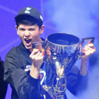 Kyle Giersdorf, who plays under the name Bugha, celebrates with a trophy after winning the final of the solo competition at the 2019 Fortnite World Cup on Sunday at Arthur Ashe Stadium in New York. | AFP-JIJI
