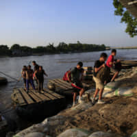 Migrants arriving from Guatemala disembark in June from a raft in Ciudad Hidalgo, Mexico. Guatemala\'s presidency said Sunday a meeting between Guatemalan President Jimmy Morales and U.S. President Donald Trump would be rescheduled due to legal appeals aimed at preventing Morales from acceding to Trump\'s requests for migrants to remain in Guatemala while they apply for U.S. asylum instead of waiting at the Mexico-U.S. border. | AP