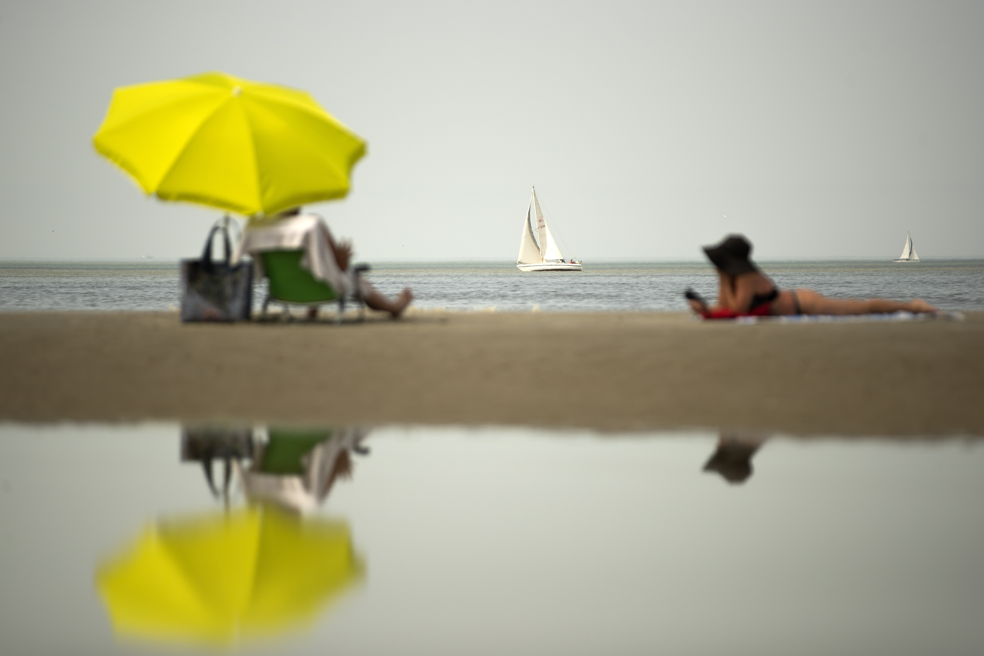 Sunbathers lie on the beach in De Haan, Belgium, on Thursday as Belgium experienced a 'code red' warning for extreme heat. | AP