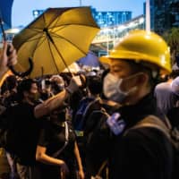 Protesters against \"parallel traders\" and police face off in the Hong Kong border town of Sheung Shui on Saturday. | AFP-JIJI