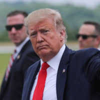 U.S. President Donald Trump returns waves after arriving in Morristown, New Jersey, on Friday. | REUTERS