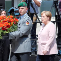 German Chancellor Angela Merkel takes part in a 75th anniversary wreath-laying ceremony at the site where officers led by Claus Schenk Graf von Stauffenberg were shot after their failed attempt on the life of Adolf Hitler, in the Bendlerblock building in Berlin on July 20. | REUTERS