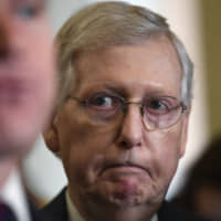 Senate Majority Leader Mitch McConnell listens as Sen. Todd Young speaks to reporters following the weekly policy luncheon on Capitol Hill in Washington Tuesday. | AP